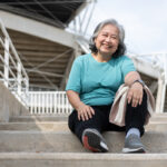 Happy And Smile Elderly Asian Woman Sitting On Stairs For Rest A