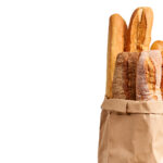 Different Types Of French Bread Baguettes In Paper Bag Over Whit